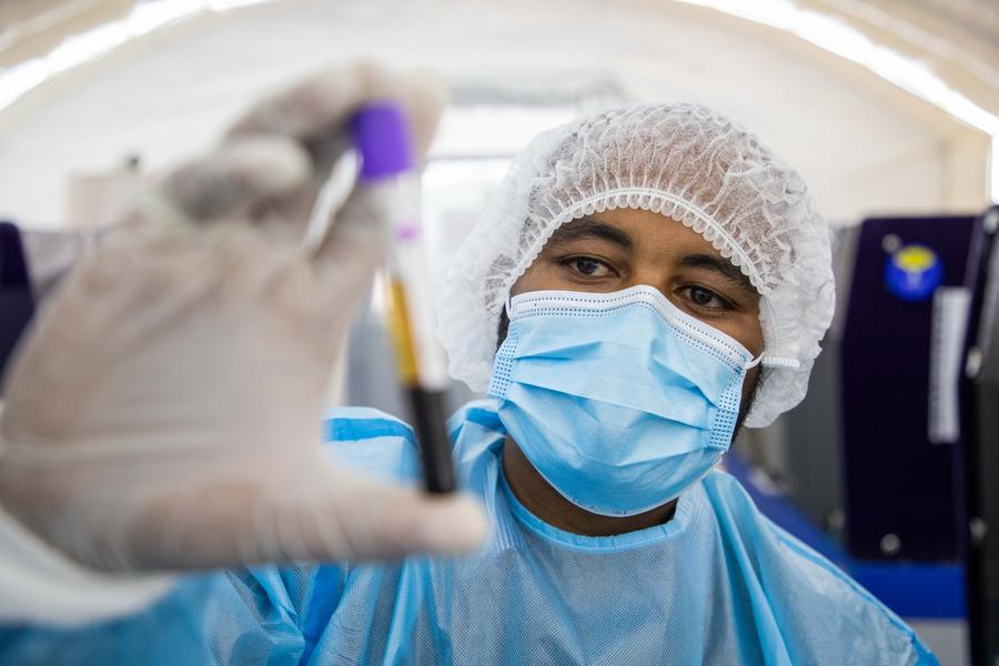 Imagen del 4 de mayo de 2022 del ingeniero de laboratorio biológico Kominist Asmamaw trabajando en una instalación de pruebas sobre la COVID-19 perteneciente a BGI Health Ethiopia, empresa subsidiaria del gigante biotecnológico chino BGI Genomics Co., Ltd. (Xinhua/Michael Tewelde)   