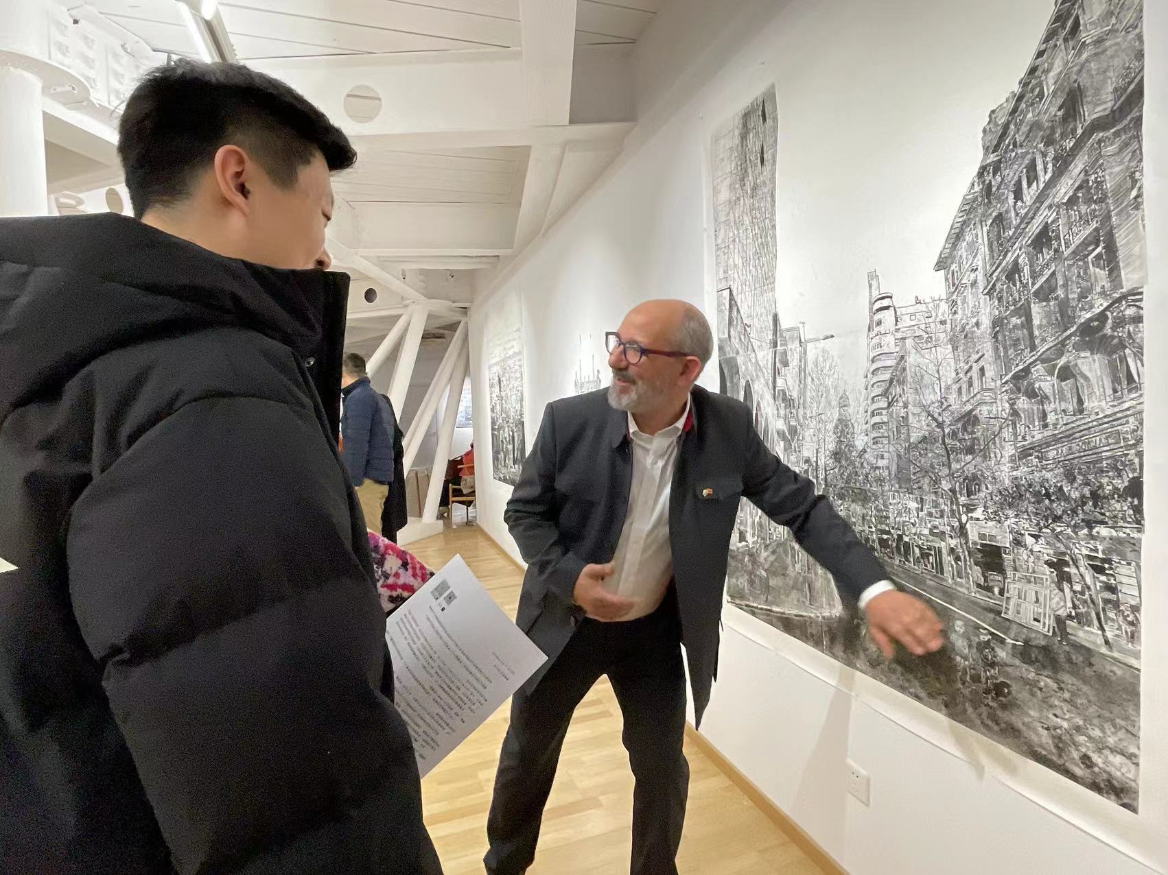 El artista Federico Arnaud dialoga con los asistentes a la inauguración de “Paisaje de los sue?os”, exposición personal inaugurada en el Centro de Arte Uruguayo de la Zona Artística 798, Beijing, 19 de diciembre del 2024. (Diario del Pueblo digital/ YAC)