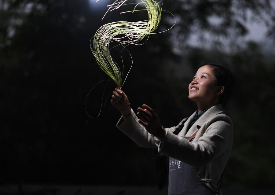 La artesana tejedora de bambú Yang Changqin muestra los hilos de bambú recién hechos en el centro de capacitación establecido por ella en la aldea de Minzu, del poblado de Datong en Chishui, provincia de Guizhou, en el suroeste de China, el 11 de noviembre de 2019. (Xinhua/Yang Wenbin)