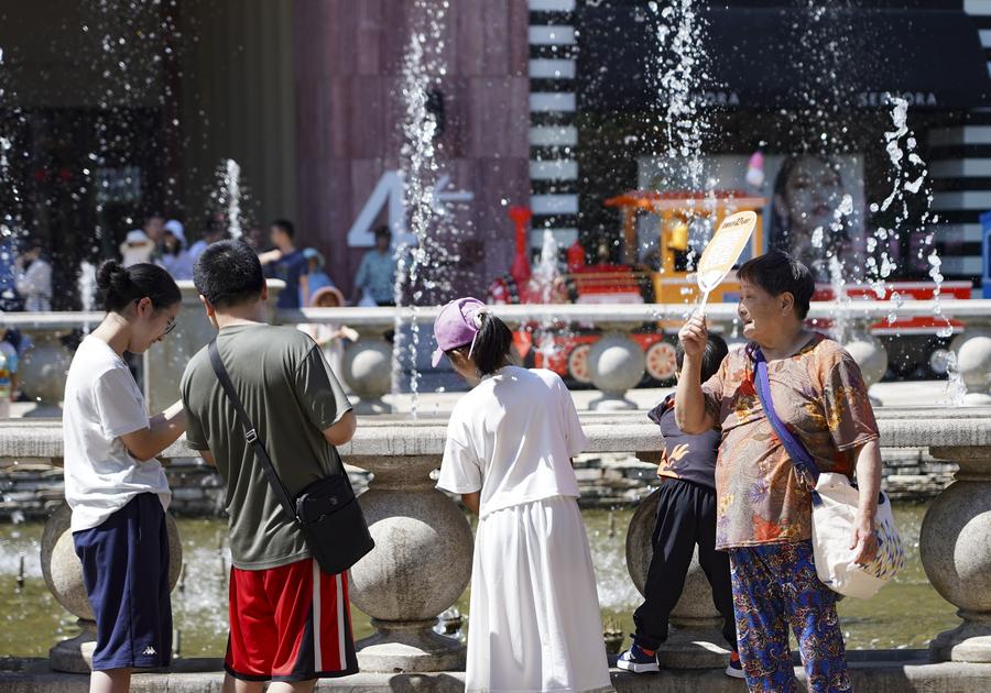 Imagen del 9 de junio de 2024 de personas refrescándose cerca de una fuente, en Beijing, capital de China. (Xinhua/Chen Zhonghao)