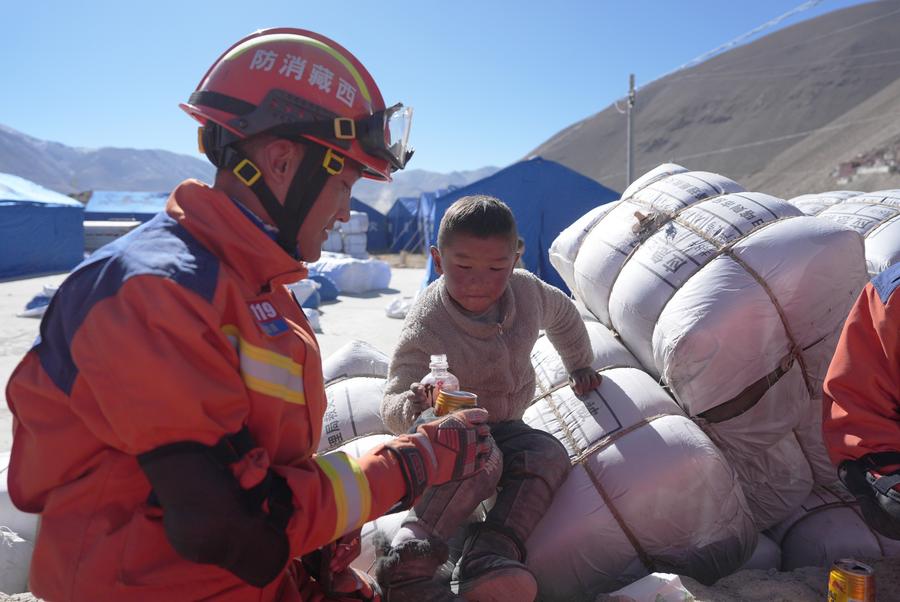 Un bombero interactúa con un ni?o en un sitio de reubicación en una aldea del distrito de Dingri en la ciudad de Xigaze, región autónoma de Xizang, en el suroeste de China, el 8 de enero de 2025. (Xinhua/Jigme Dorje)