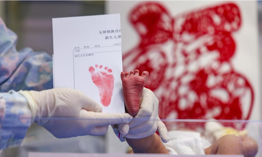 Una enfermera muestra la impresión del pie de un bebé recién nacido, cuyo signo del zodiaco chino es el dragón, en un hospital del distrito autónomo de la etnia dong de Yuping, en la ciudad de Tongren de la provincia suroccidental china de Guizhou, el 10 de febrero de 2024, primer día del A?o Nuevo lunar. (Xinhua/Hu Panxue)