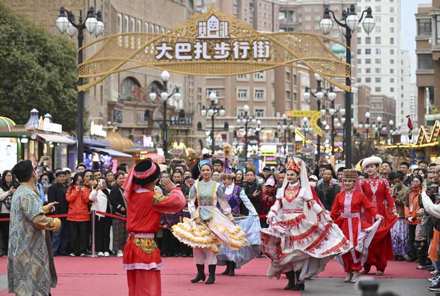 Participantes en la VI Cumbre Mundial de Medios de Comunicación presencian una danza en el gran bazar de Urumqi, capital de la región autónoma uygur de Xinjiang, en el noroeste de China, el 16 de octubre de 2024. (Xinhua/Hu Huhu)